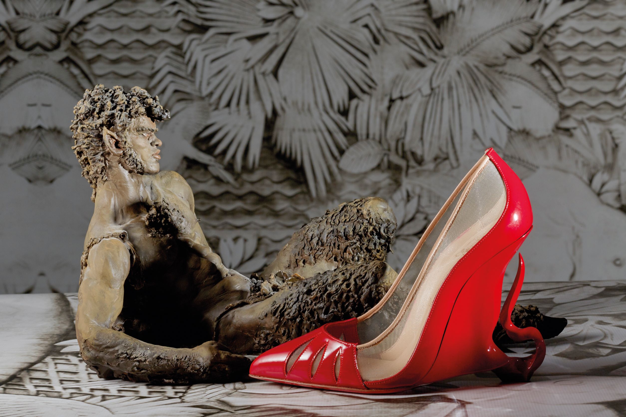 Christian Louboutin 以「黑魔女」為靈 感， 替女主角裘莉設計了一款名為「Malangeli」，充滿闇黑魅惑又性感致極的紅底高跟鞋，最大特色在於彎曲的鞋跟搭配上裸色的絲網設計，彷彿在煙霧裊裊當中醞釀著一個邪惡巫后的化身。