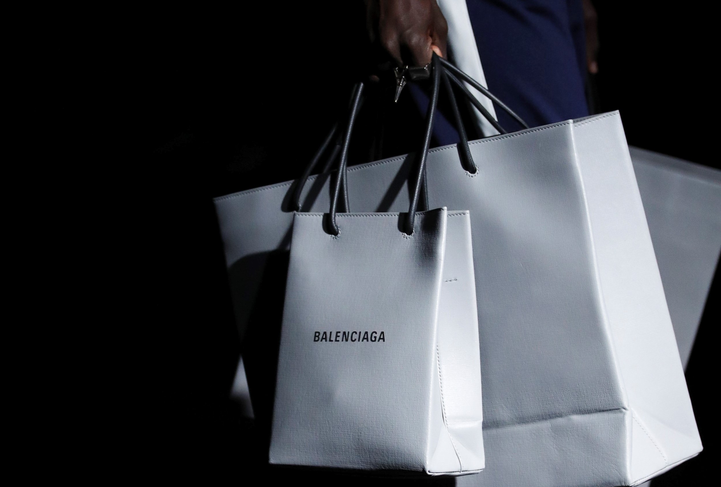 在 2019 秋冬大秀上，Demna Gvasalia 持续用设计反映他眼中的「巴黎人日常」，推出印有 Balenciaga 的仿购物纸袋皮革包。