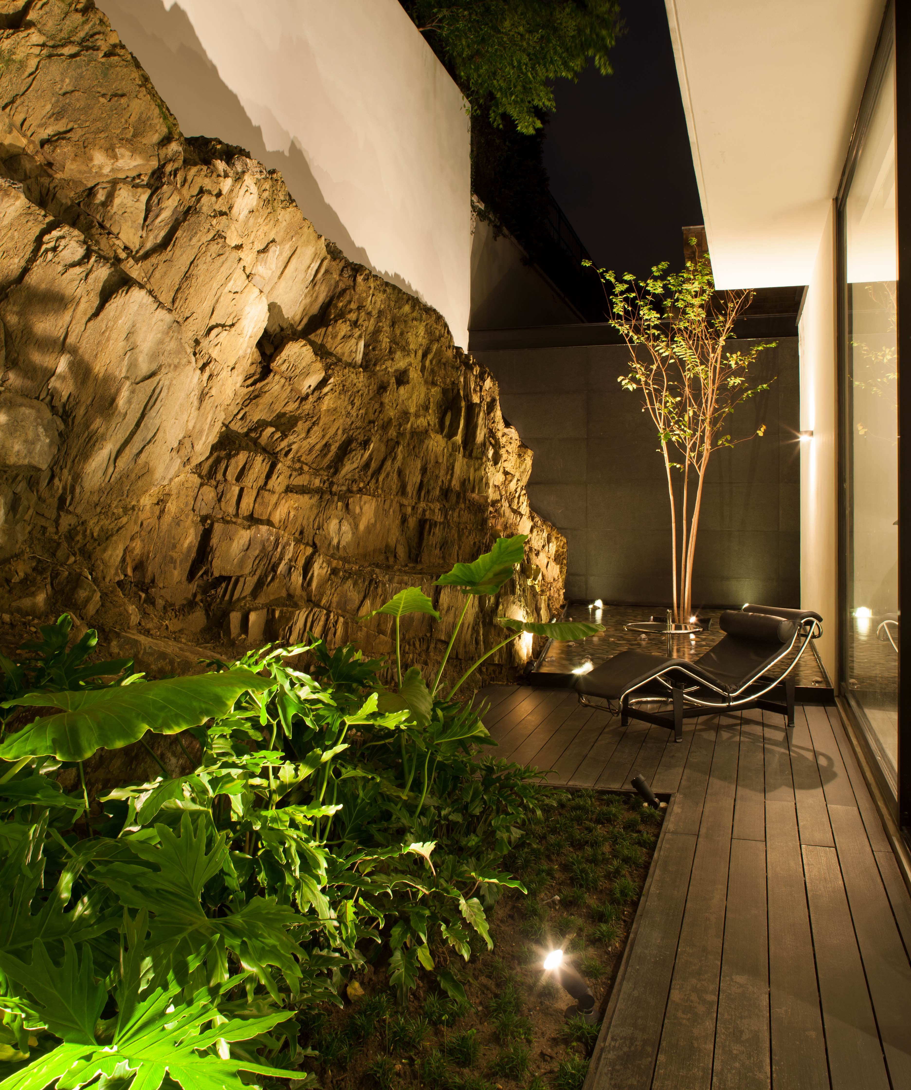 減少花園面積，以岩石牆砌出住宅另一側的自然風光。