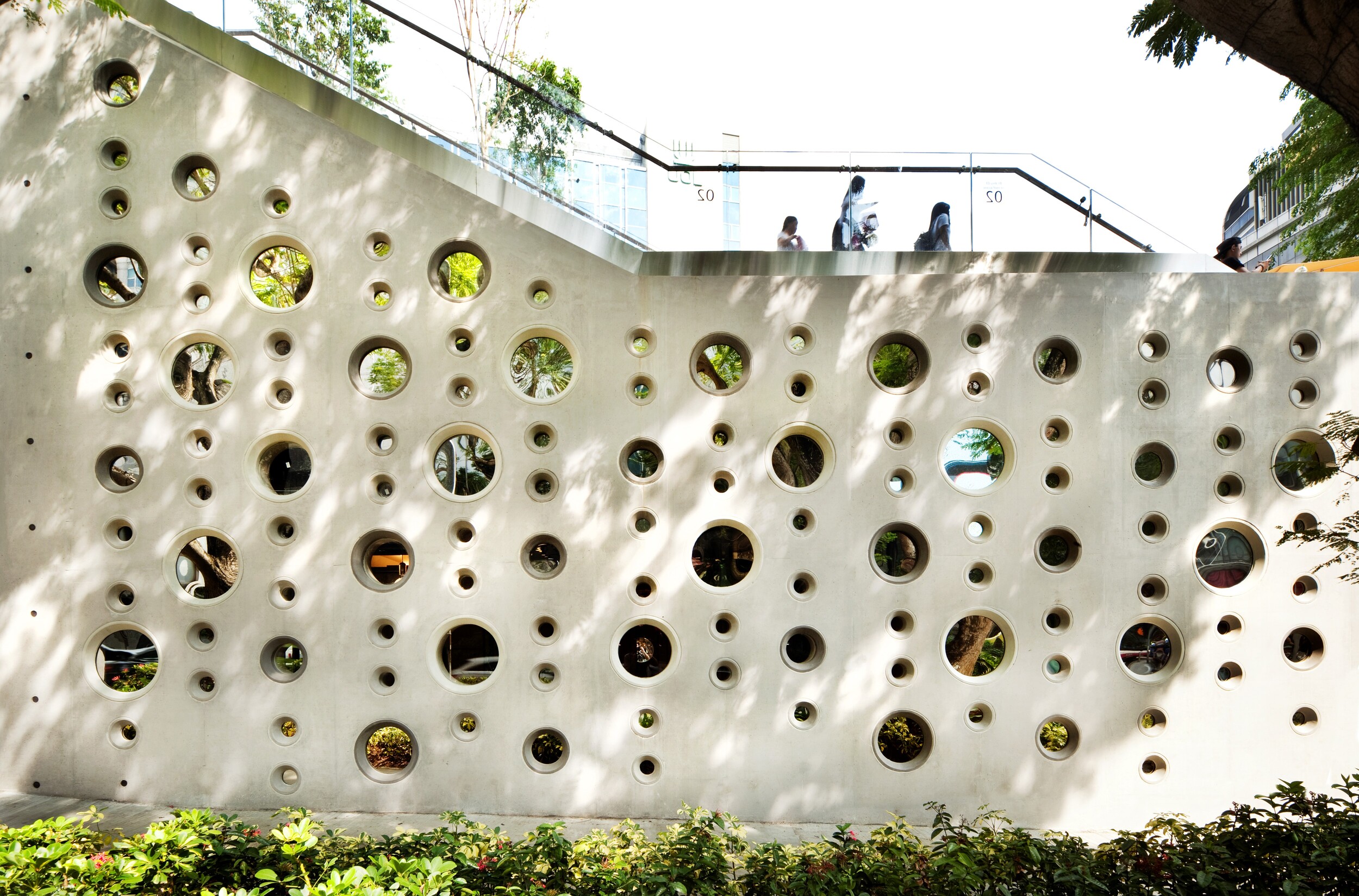 布滿圓形孔洞的混凝土牆， 建構出窺探創作的設計意趣。