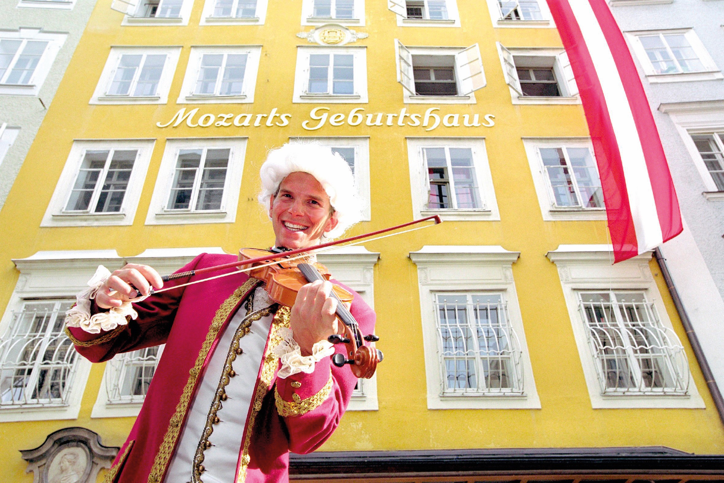 莫札特出生地紀念館外，可見街頭藝人即興演出莫札特音樂。（© Tourismus Salzburg）
