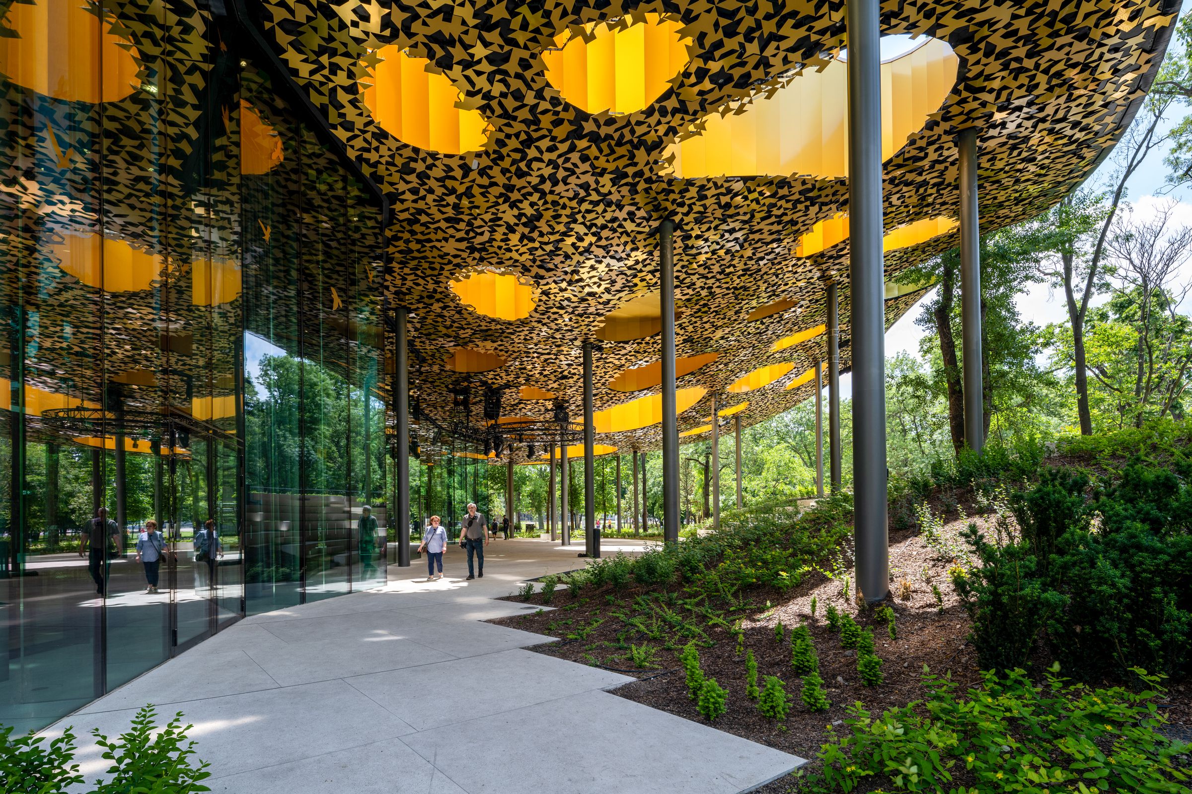 鑲滿金色樹葉形裝飾的天花板和圓柱形支撐結構，讓音樂之家與周遭自然環境相互延續。(Liget Budapest © Palkó György)