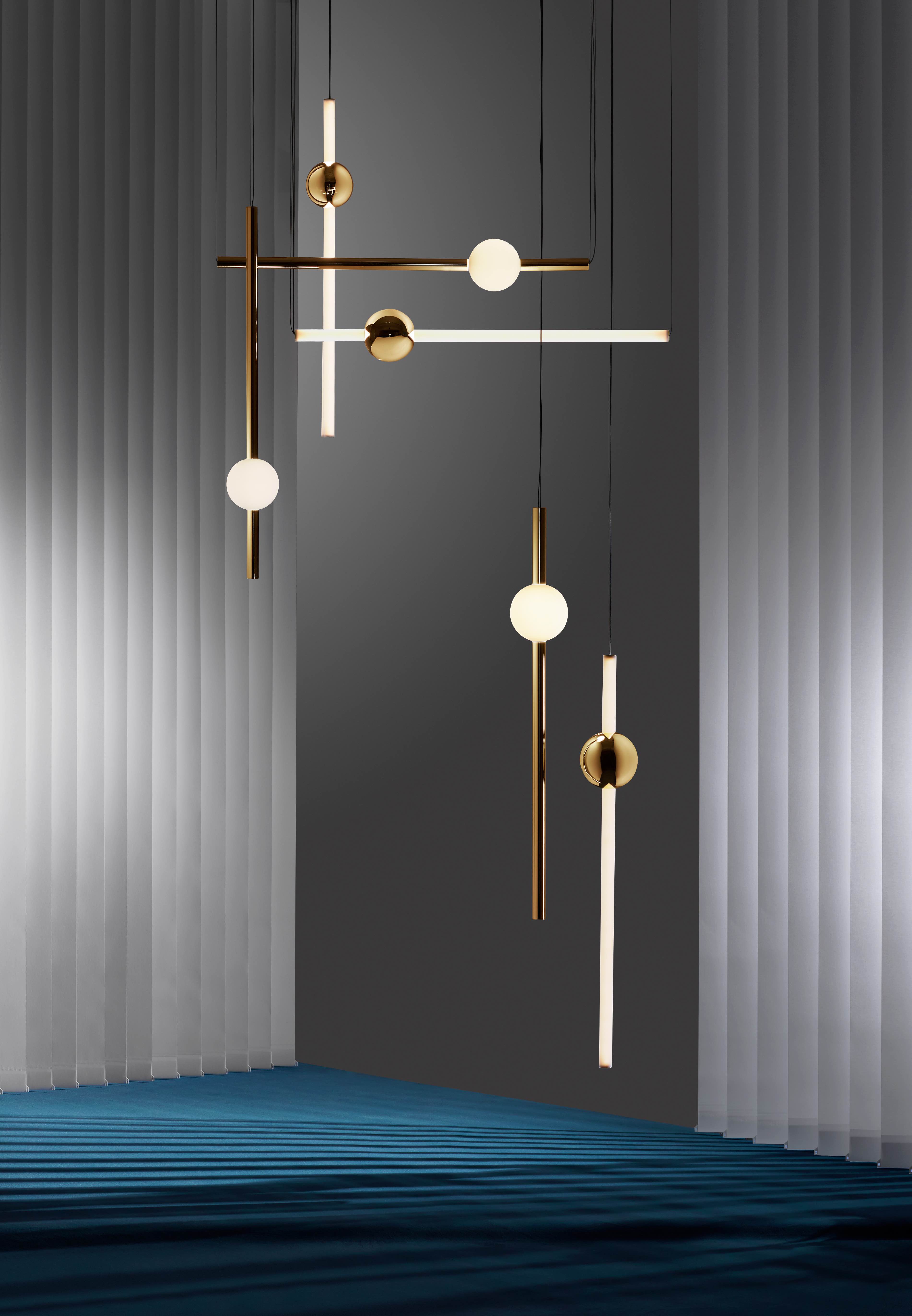 以拋光金球體及拋光金管打造而成的 Orion 吊燈系列，將水平和垂直的設計尺度擴展到極致。