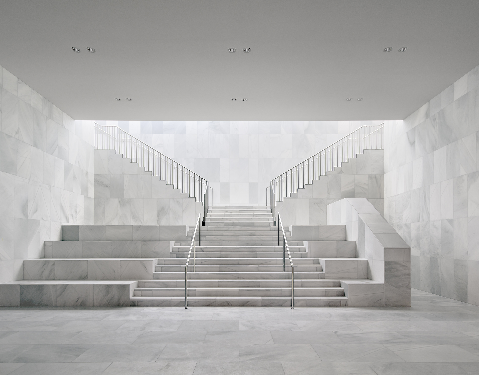 地下展廳的入口階梯，以大理石鋪陳出結合當代極簡風格與宮殿恢弘氣勢的空間美學。