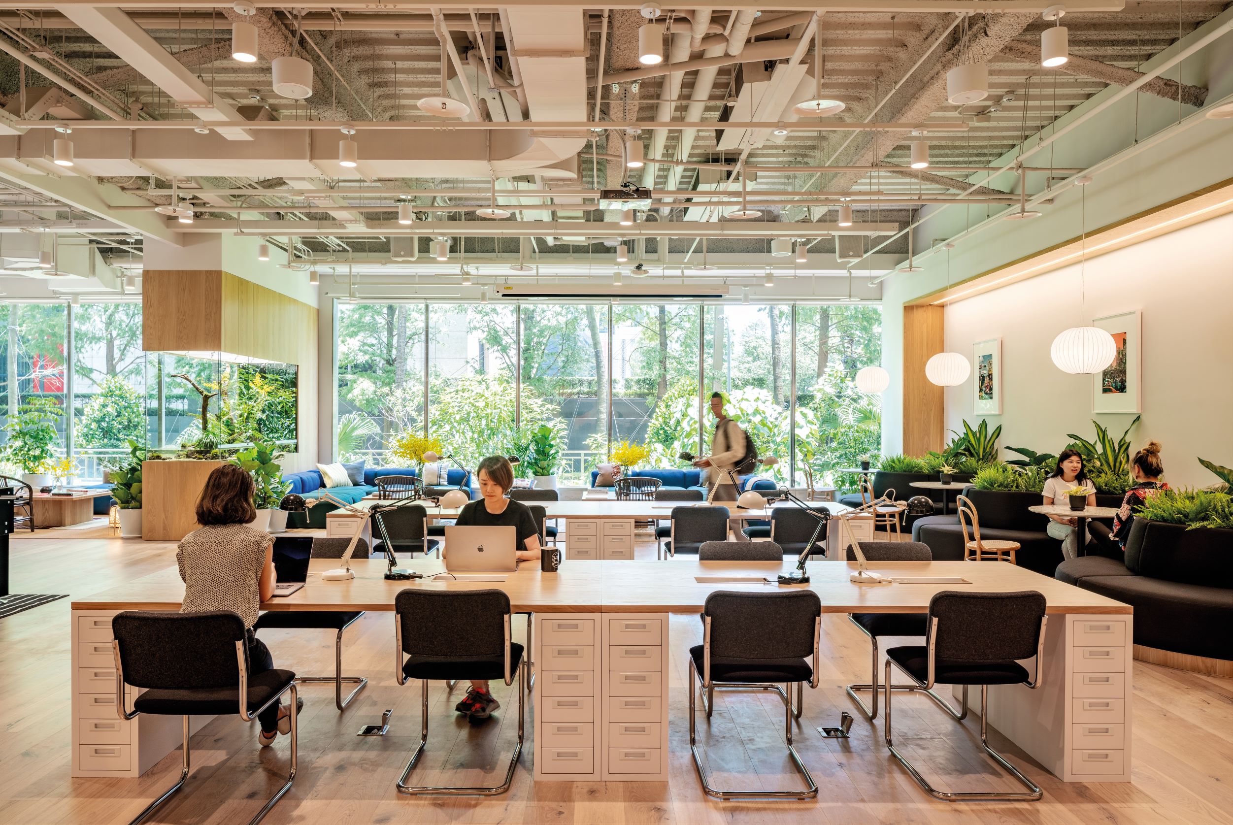 以台湾的山海森林为设计灵感的 WeWork 台北，不仅工作空间里满是绿意，玻璃墙外也是一片绿意盎然。