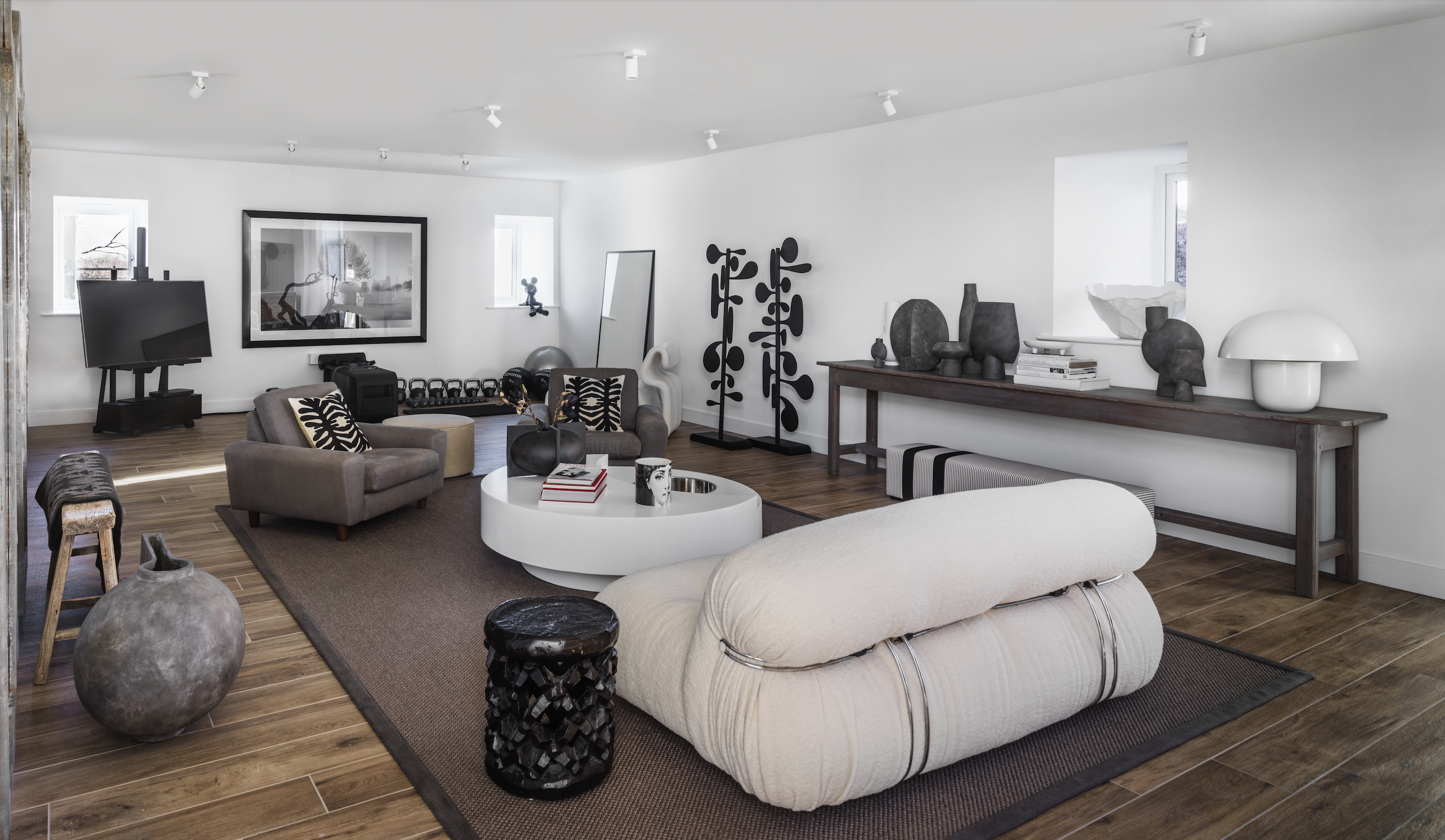 白色基調的起居空間，現代家具、藝術創作和復古軟裝、自然材質兼容並蓄，悠閒中不失時髦。