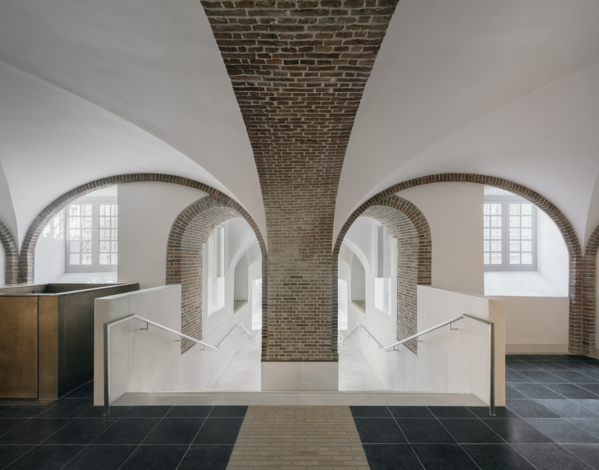 連接地下展廳的入口通道，以多層次的拱形結構和窗戶設計，營造出帶有層疊延伸感的幾何設計風情。