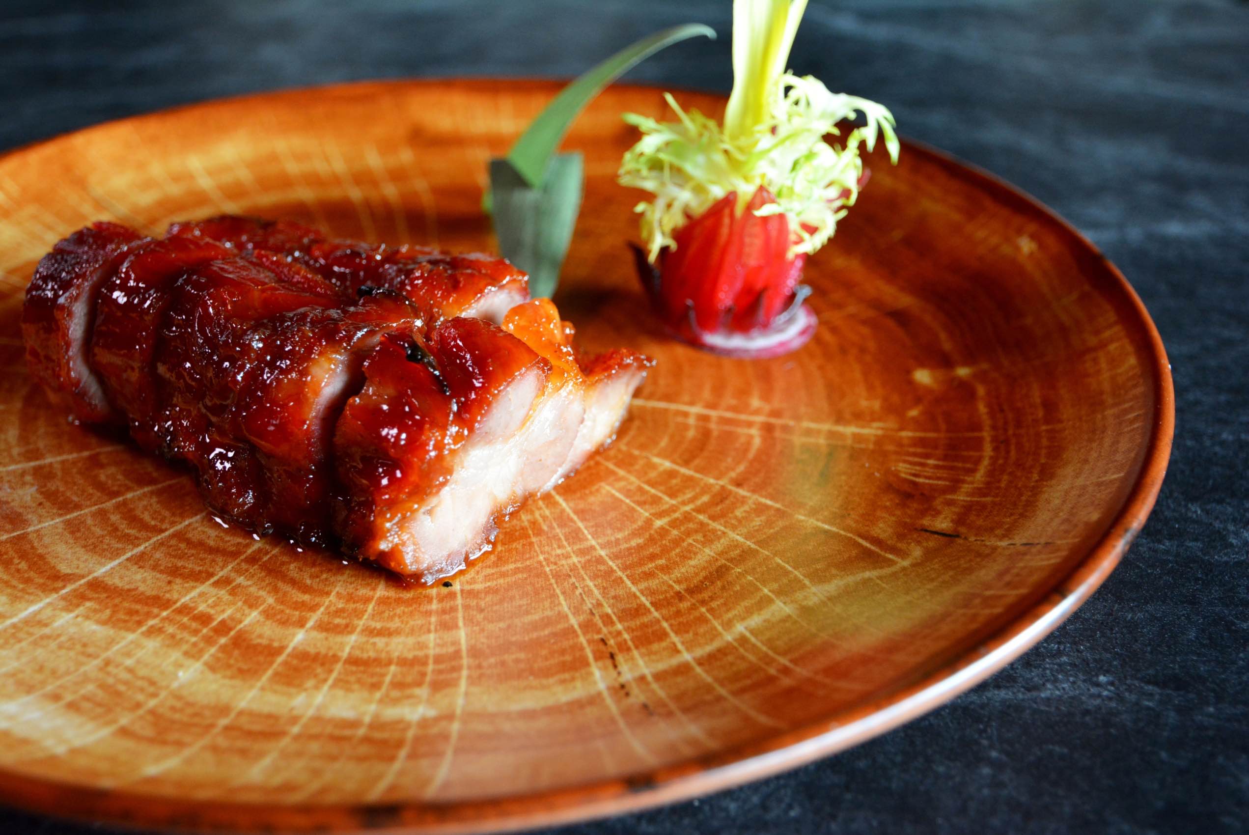 玫瑰叉燒在上桌前淋上玫瑰露酒炙燒，香氣迷人，甜嫩可口。