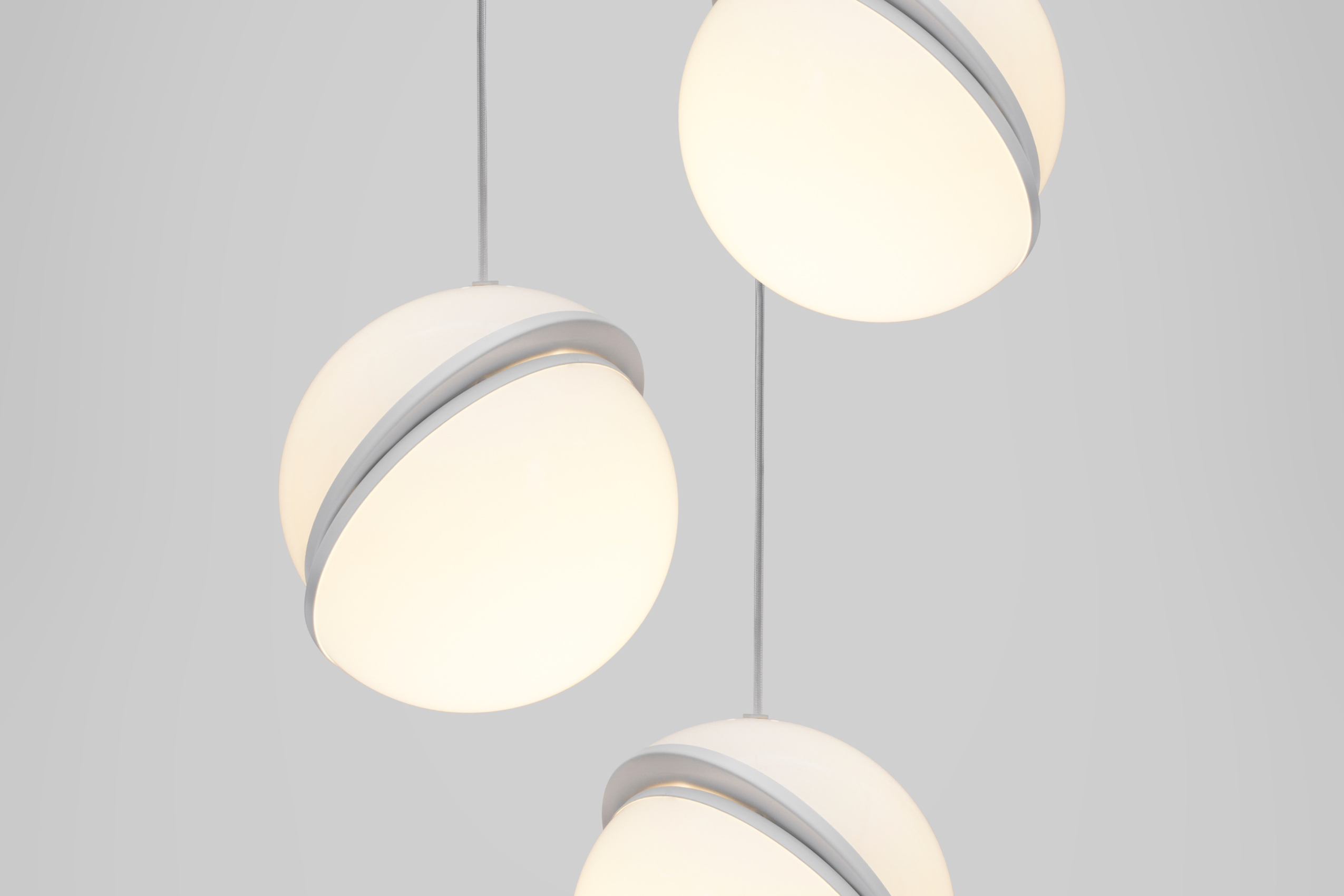 趣味的將球體切成兩半，露出一個新月形的拉絲黃銅面板，Crescent 吊燈完美呈現固體和不透明體無縫地結合的創意。