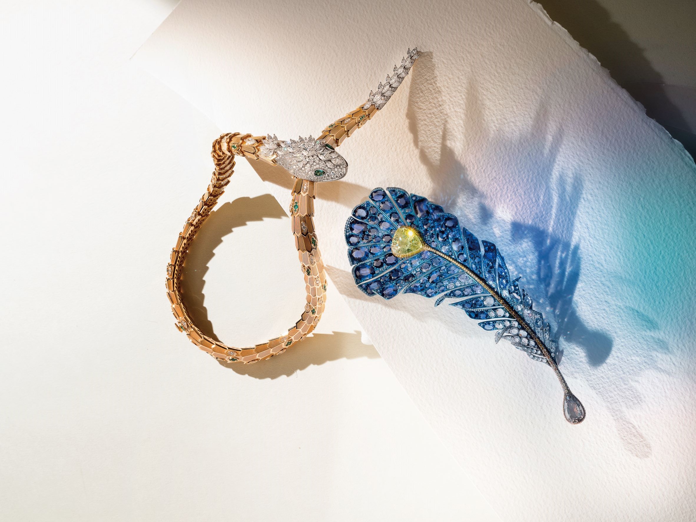 由左至右：Serpenti 系列頂級祖母綠與鑽石項鍊，Bvlgari。2019 大師系列III皇家藍羽飾胸針，Cindy Chao The Art JeweL。