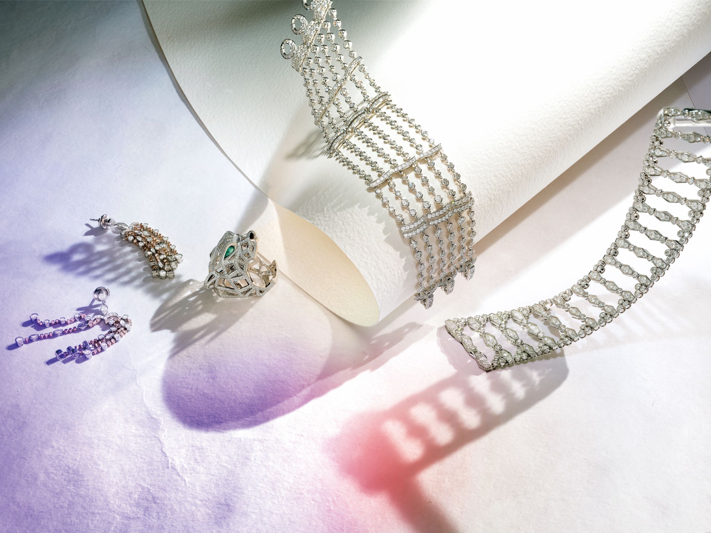 由左至右：Tiffany 粉鑽與白鑽流蘇耳環，Tiffany & Co.。Panthère de Cartier 美洲豹鏤空鑽石戒指，Cartier。Pluie de Cartier 18K 白金鑲鑽手鍊，Cartier。