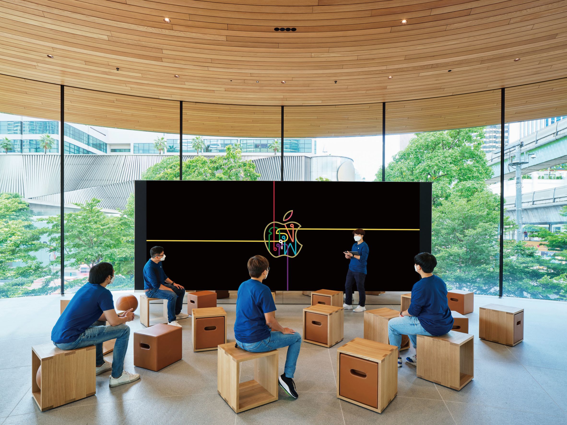 Apple Central World 也规划有可灵活利用的论坛空间，并使用可自由移动的木箱式座椅，来与建筑的木质感相配搭。