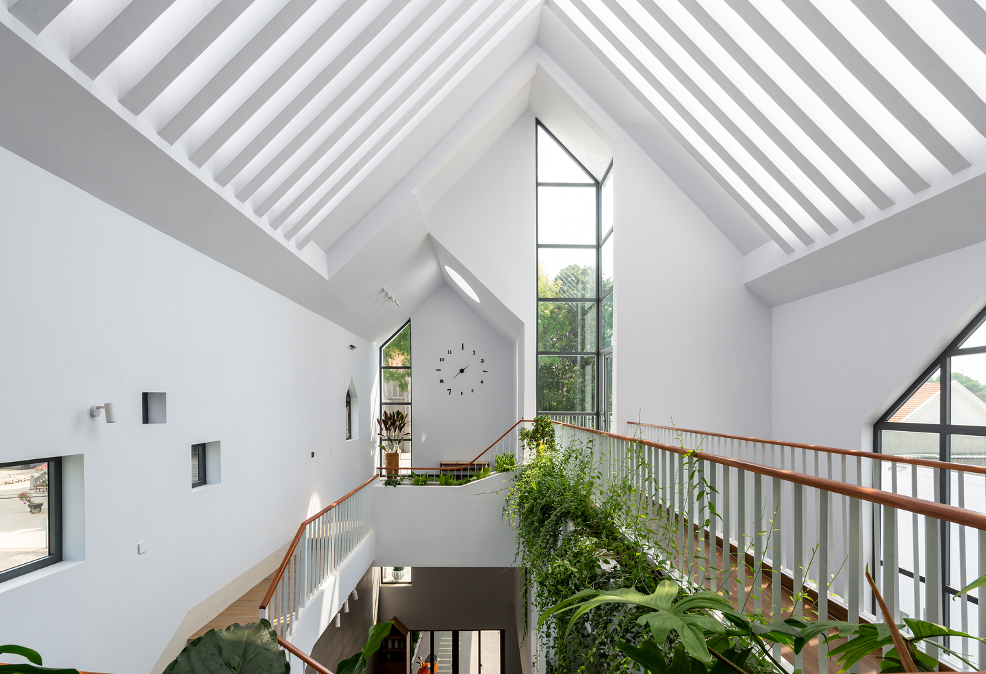 Gather House 在三角形的屋頂上，以玻璃天窗搭配條狀混凝土結構，營造出光從天而降的意境。
