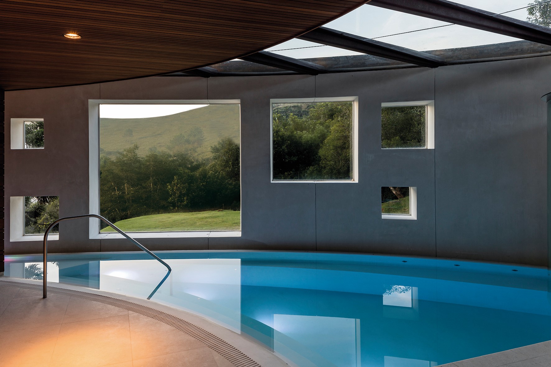 位於 1 樓的室內泳池，即使受限結構，建築師依然盡可能開窗，為室內框住戶外的自然風景。