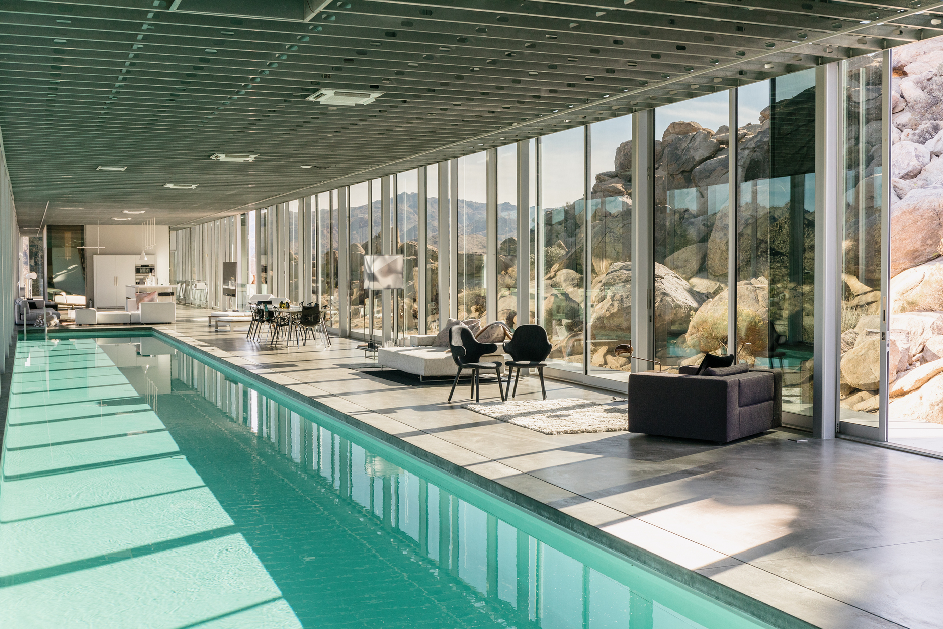 長 100 英尺的室內泳池搭配玻璃牆幕，營造出前衛又超現實的空間場景。