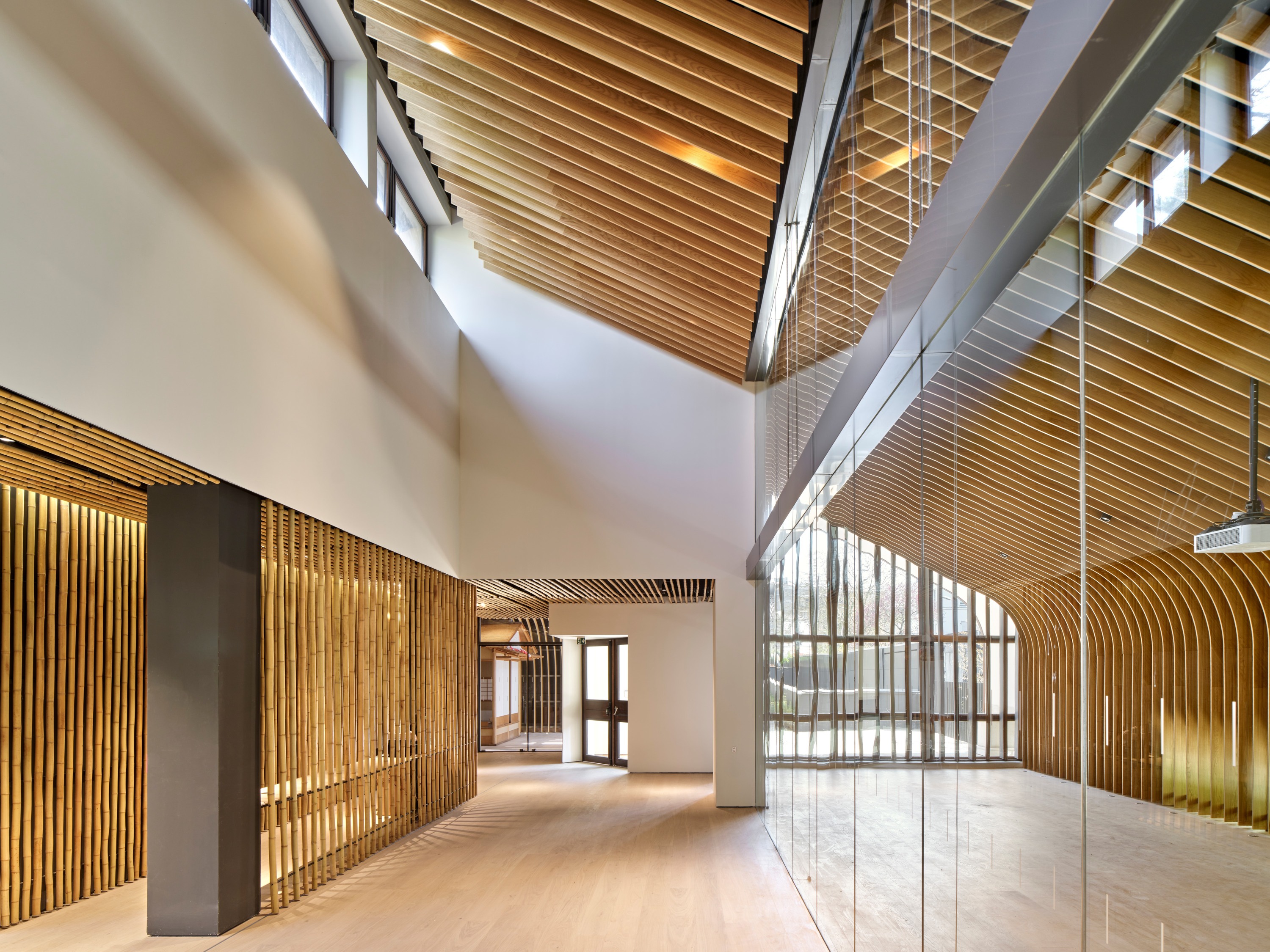 館內以天花板原木裝飾，對應木質階梯，創造出不斷交會延伸的空間景觀。