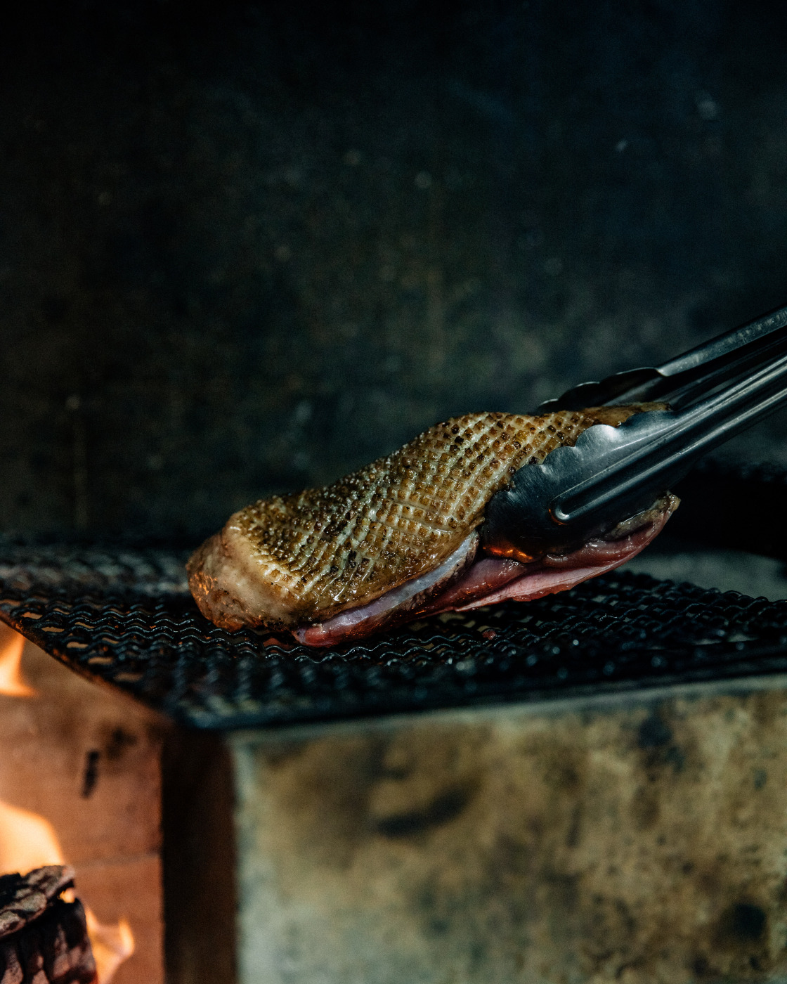 生江史伸舍弃了一般厨房常见的瓦斯烤箱， 改用原始的炭火烧烤料理方式，来落实减碳。 （Photo by Nathalie Cantacuzino）