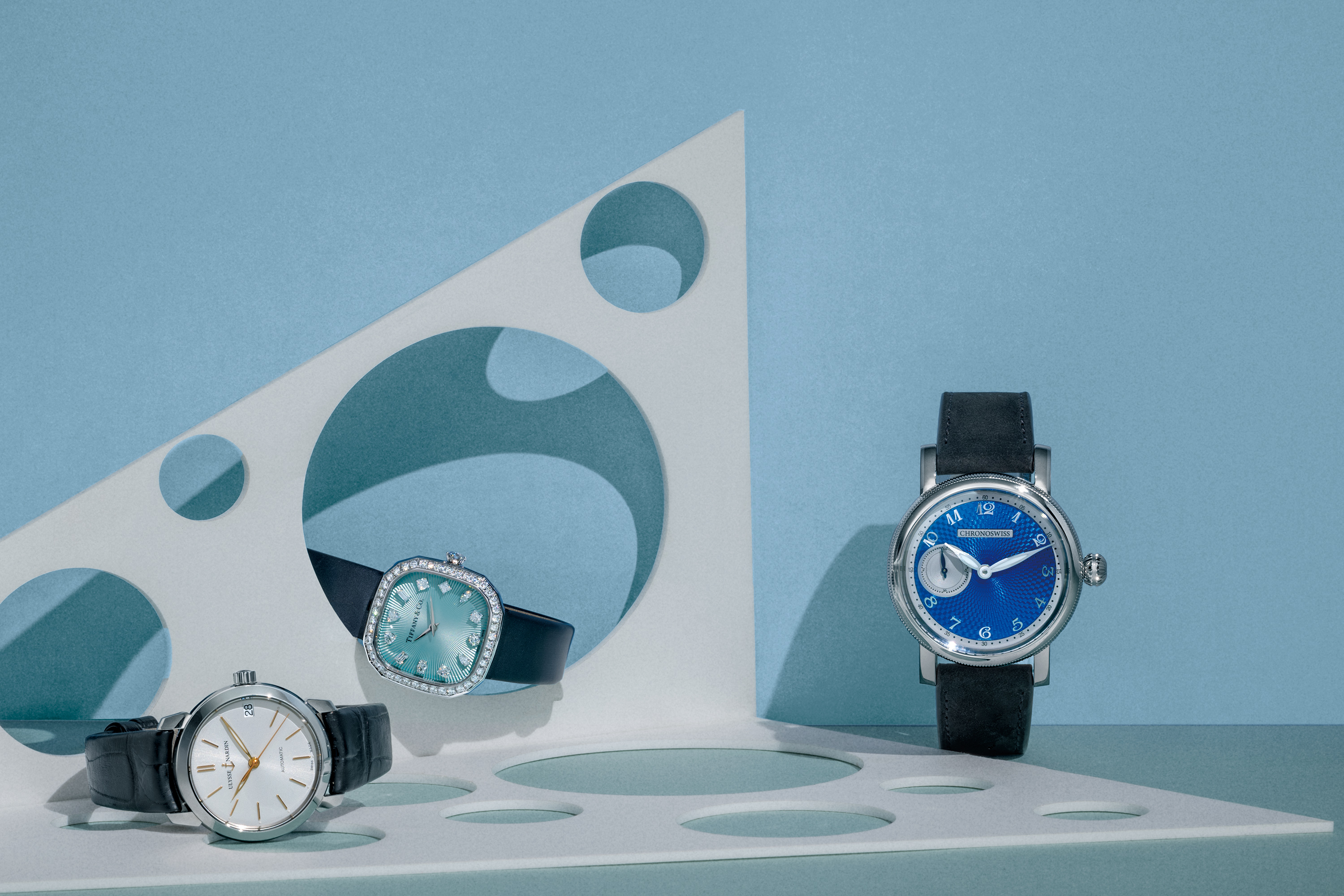 （左） Ulysse Nardin 鎏金系列自动腕表，搭载 UN-810 自动上链机芯，不锈钢表壳，时间显示，表径 31mm ，防水深度 30 米。 （中） Tiffany & Co. Eternity 枕形腕表，搭载高度精确瑞士石英机芯，18K 白金表壳镶钻石，时间显示，尺寸 28mm ，防水深度30 米。 （右） Chronoswiss Small Second 腕表，搭载瑞宝自制自动上链机芯 C. 6000，不锈钢表壳，时间显示，表径 40mm。