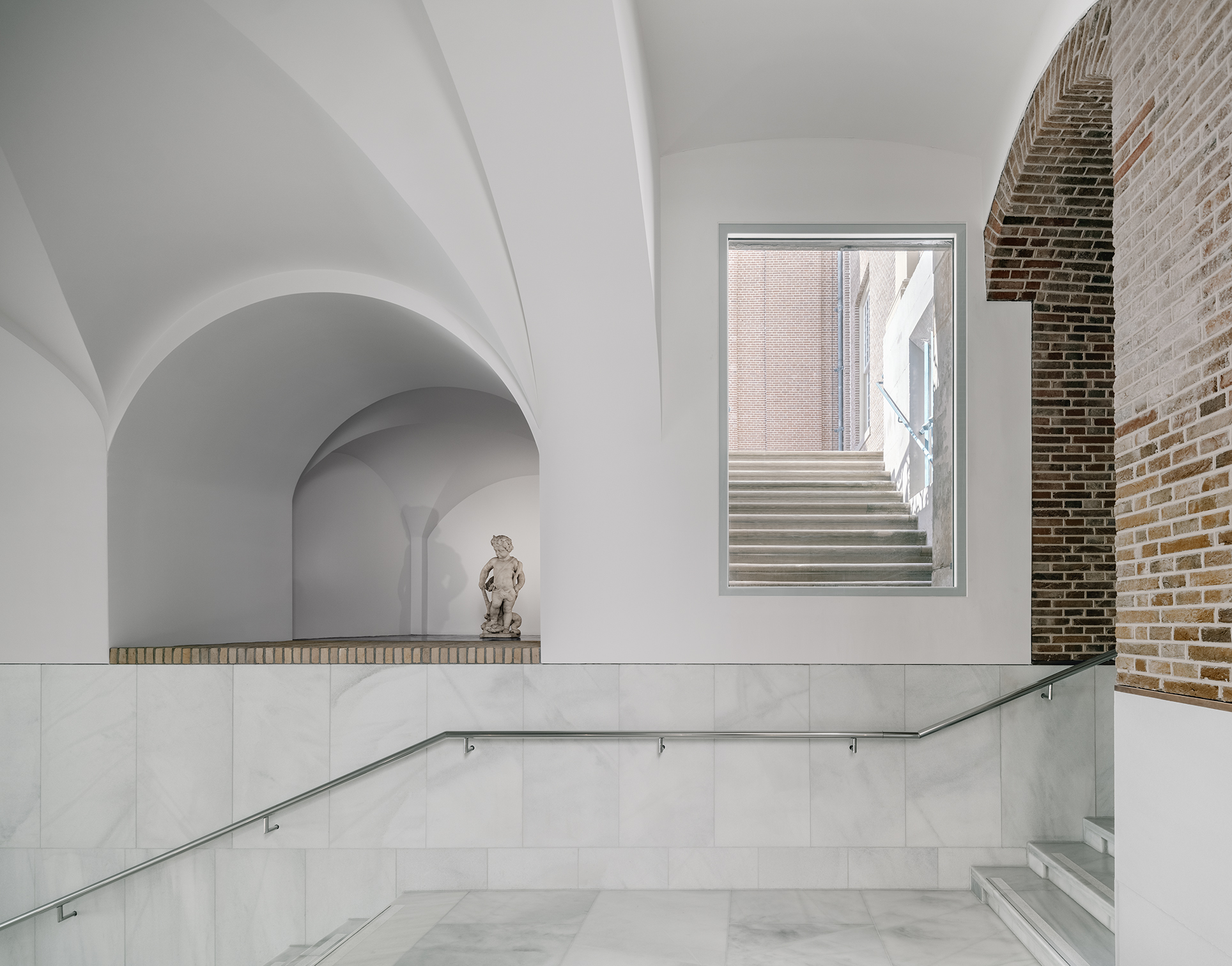 地下展廳以磚牆拱門和大理石牆面，創造出鮮明的材質對比。
