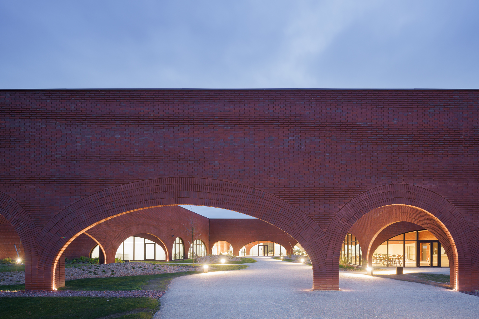 Maroquinerie De Louviers 以拱形結構和玻璃牆幕，建構出堅固與輕盈並行的磚造建築樣式。
